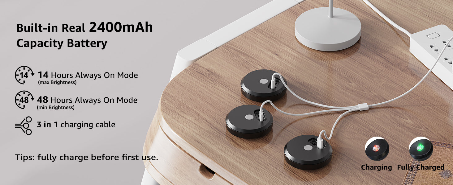 Black puck lights with charging cable on a wooden surface, battery capacity information displayed.